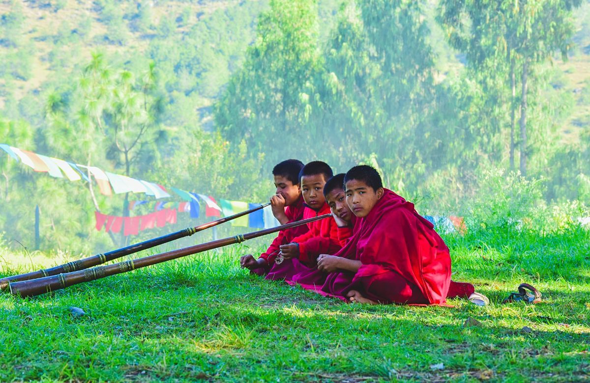 Young monks standing beside prayer flags